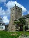 A stone church seen from the south-east with a square, battlemented tower to the left. Part of the body of the church can be seen extending to the right.