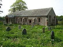 A long. low, small church with a small west bellcote seen from the southeast