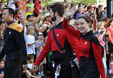 People wearing Star Trek: the Next Gneration uniforms in a parade.