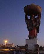 Statue towering over two men