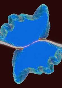 Central star has elongated S shaped curve of white emanating in opposite directions to the edge. A butterfly-like area surrounds the S shape with the S shape corresponding to the body of the butterfly.