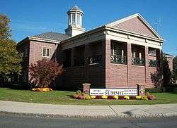 Picture of a modern brick two-story building with a steeple and a sign saying "Summit" City Hall