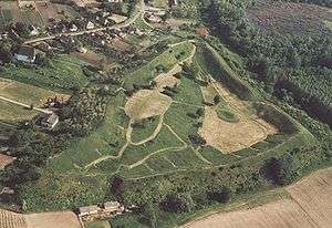 A piece of land surrounded by earthwork covered by trees