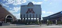 Large sign saying "M", towering above a football field