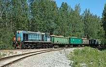 A colour photograph of a train with open cars carrying oil shale near Ahtme, dated to June 2007. The locomotive is on the left.