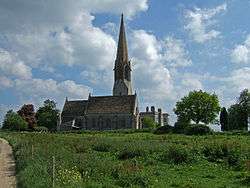 Stone building with spire above a square tower.