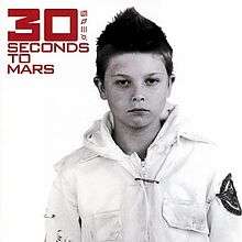 A boy with short hair. He wears a white jacket with a print on the left arm. In the top left, the words "30 Seconds to Mars" and four symbols are written in red font, with the "30" in bold.