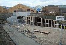 Path to a tunnel in the distance, running beside construction work.