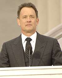 Photo of Tom Hanks standing behind a podium at the Lincoln Memorial in 2009.