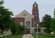 1990s brick building with square pyramidal-topped steeple, clear glass windows