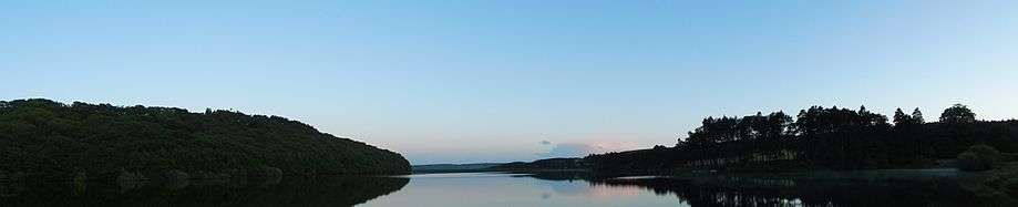 View looking south down Tunstall Reservoir at sunset with Backstone Bank wood on the left.