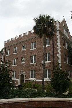 Exterior of Buckman Hall, a red brick and carved stone student residence hall at the University of Florida, built in 1905–06 in the then-popular collegiate gothic architectural style.