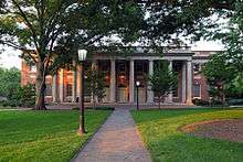 A large brick building with columns on the front and three doors.