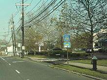 A road in a suburban area with a sign reading Mercer County 616 right