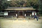 Frontal view of a rather low and wide building with wooden beams and white painted walls.