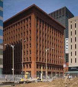 dark red seven story building in front of construction site