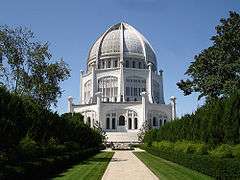 A white domed building with a large garden leading toward it