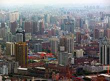 A cityscape of buildings of various heights, seen from above, gradually disappearing into a haze in the background